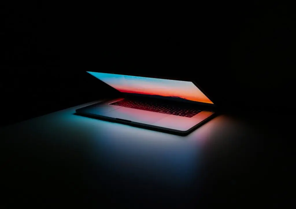 laptop half open with black background