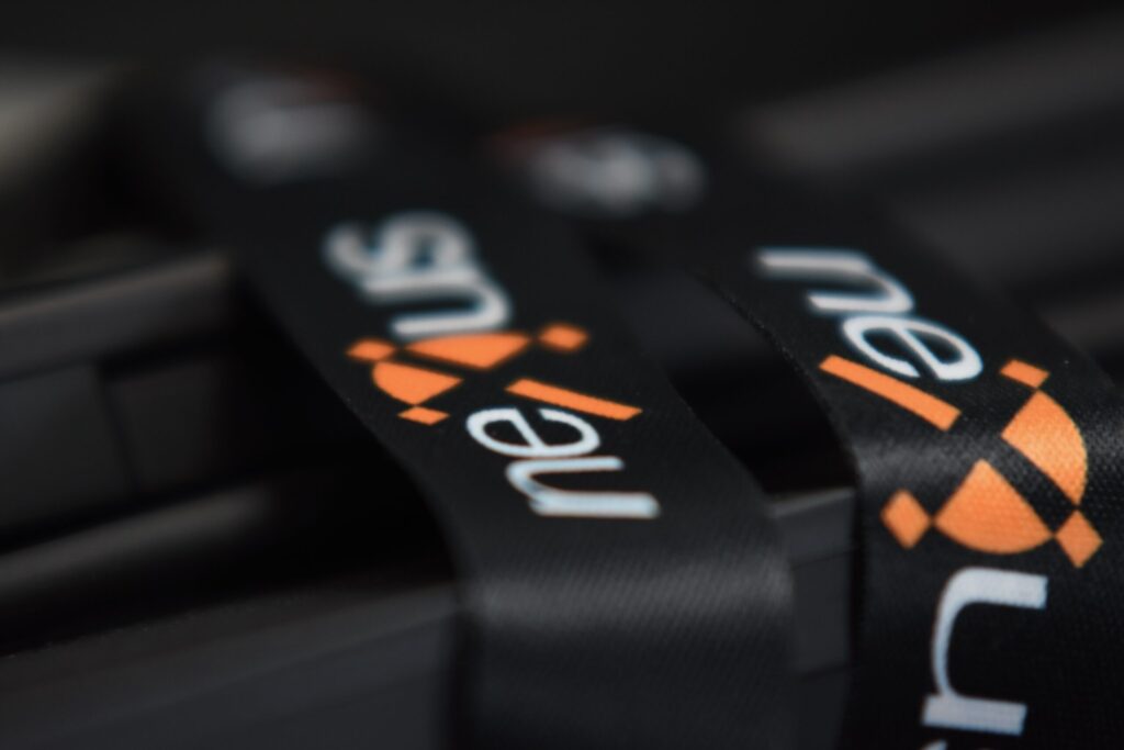 Black fabric lanyard featuring the Nexus logo in white and orange