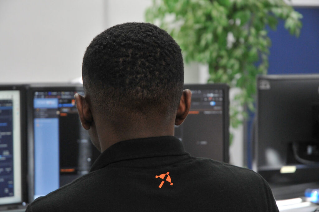 Nexus IT engineer monitoring systems on dual screens in the office
