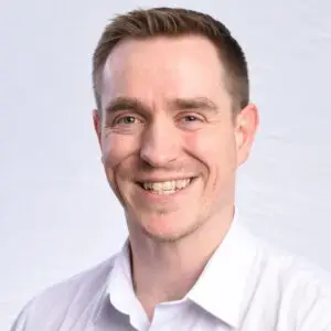 Professional headshot of a smiling man