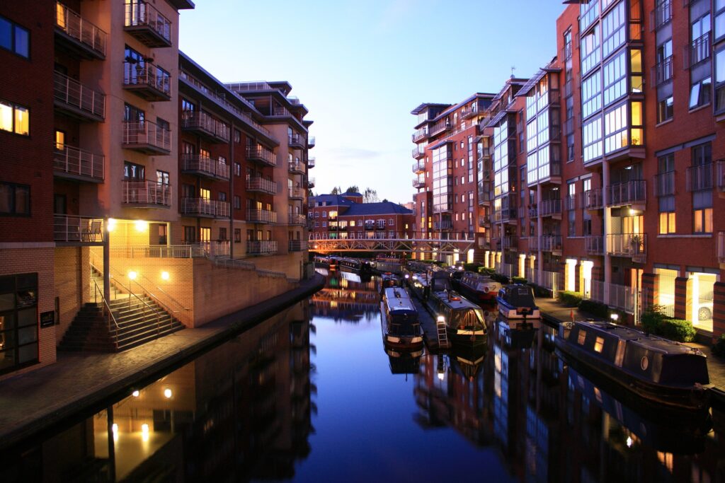 Evening view of a modern canal-side residential area with moored boats