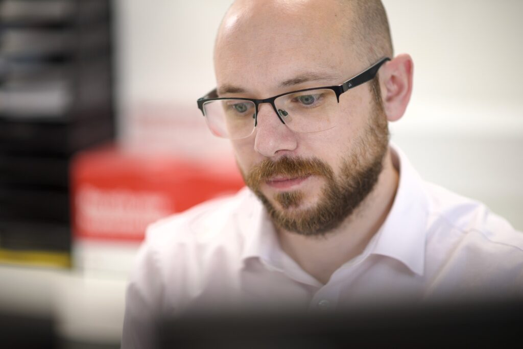 Nexus IT professional wearing glasses focused on work in the office