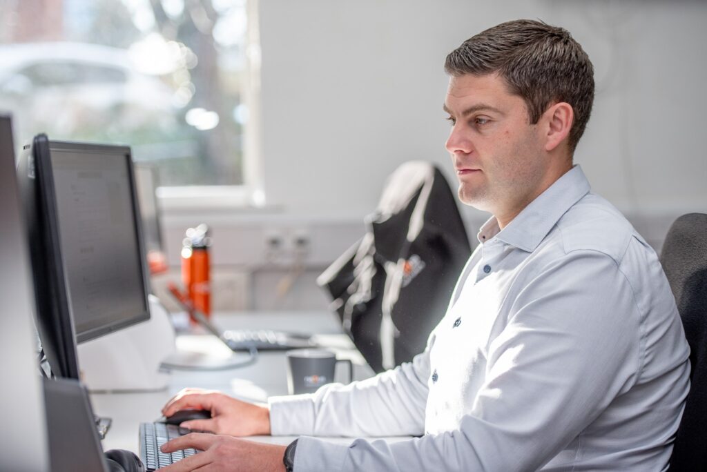 Nexus team member working on dual monitors in the office