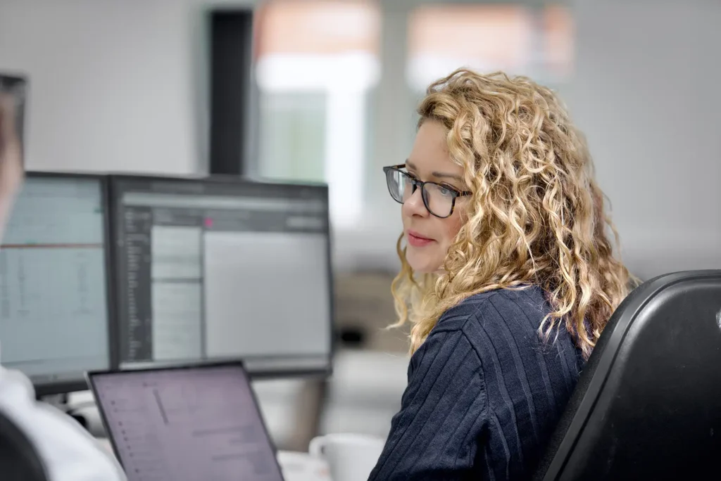 Nexus IT Experts employee working at multiple monitors in the office