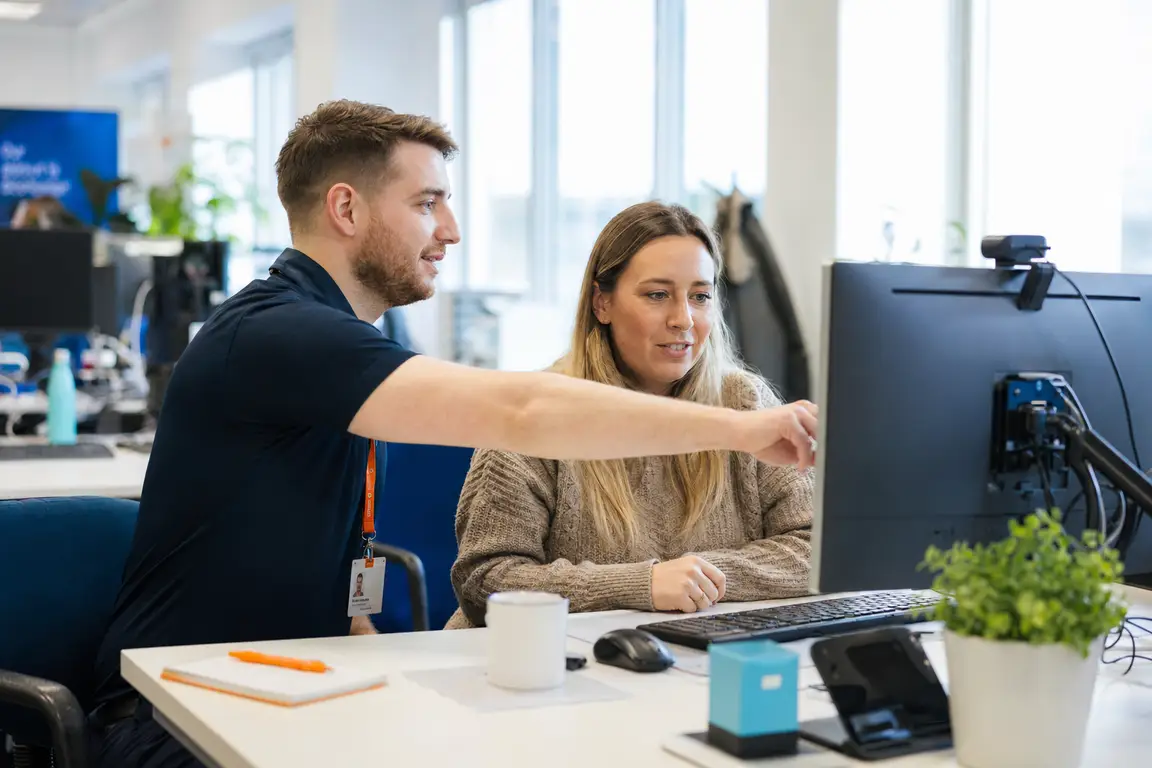 A friendly IT professional supports a service user with a task