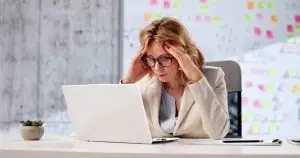 Business owner reviewing company finances on a laptop while dealing with operational challenges and business continuity planning