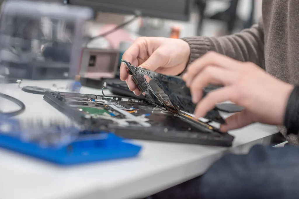 Close-up of Nexus IT expert disassembling and fixing a laptop motherboard
