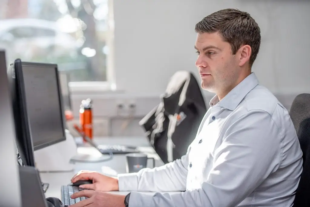 Side profile of a woman working at her desk.