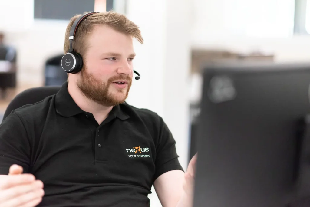 Nexus IT support specialist wearing a headset and engaging in a client support call.