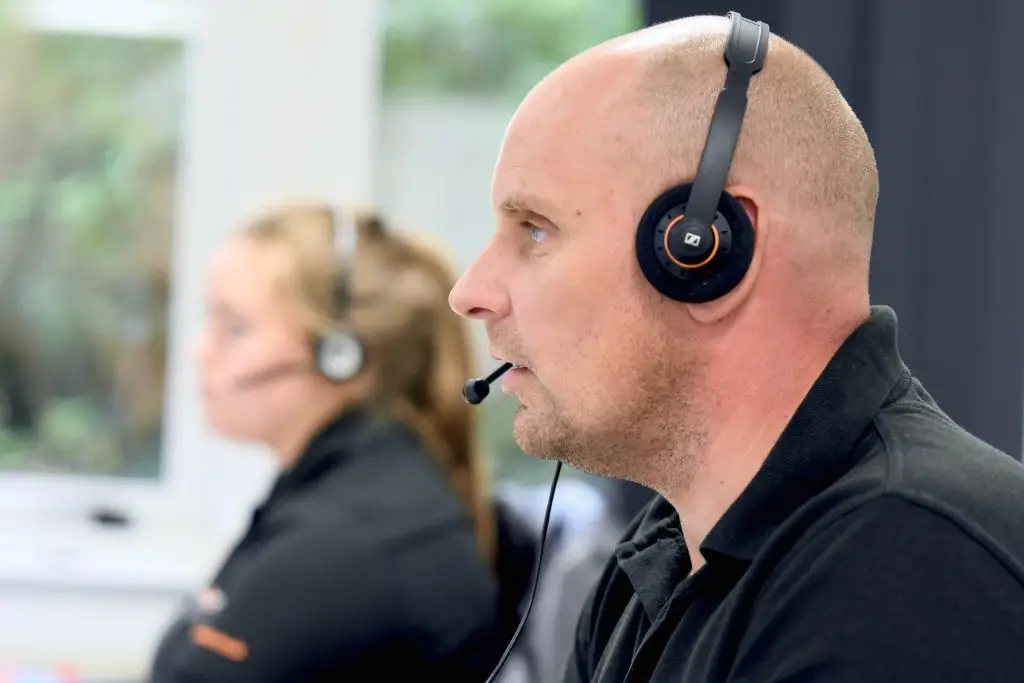 Security analyst wearing a headset monitoring alerts as part of a dark web monitoring service