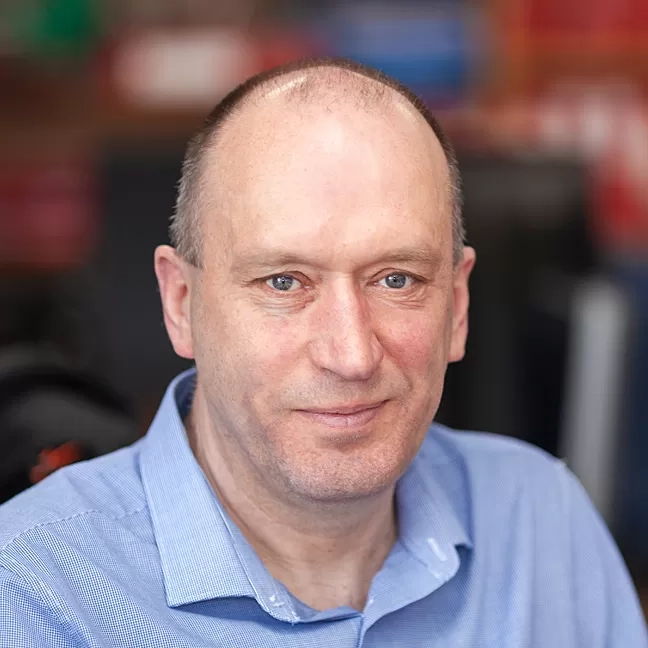 Headshot of a Nexus IT Experts staff member wearing a light blue shirt in the office