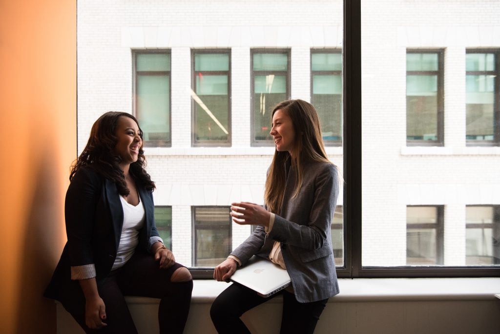 Two colleagues sitting by a large office window